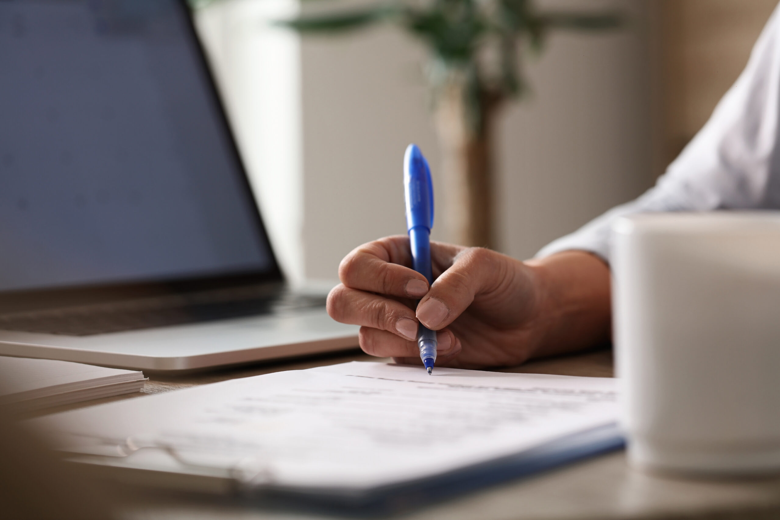 Close up of businesswoman signing documents in the office.